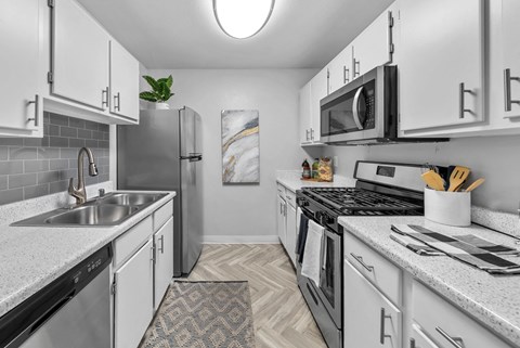 a kitchen with white cabinetry and stainless steel appliances