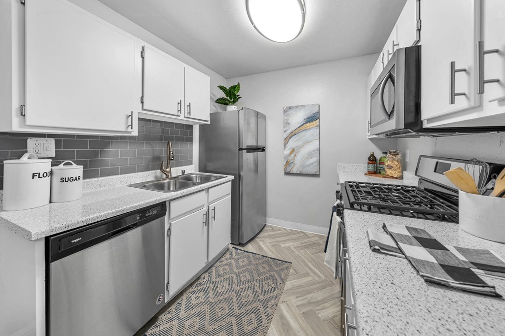 a kitchen with white cabinetry and stainless steel appliances
