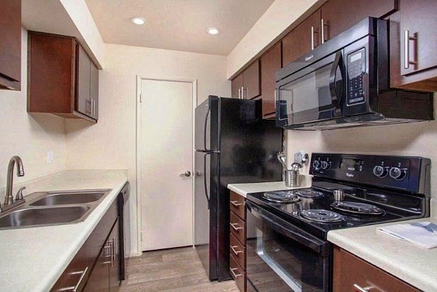 a kitchen with a stove and a refrigerator and a sink