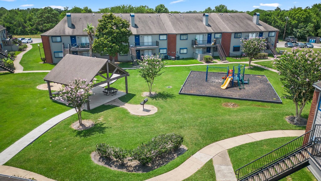 an aerial view of a park with a playground and an apartment building