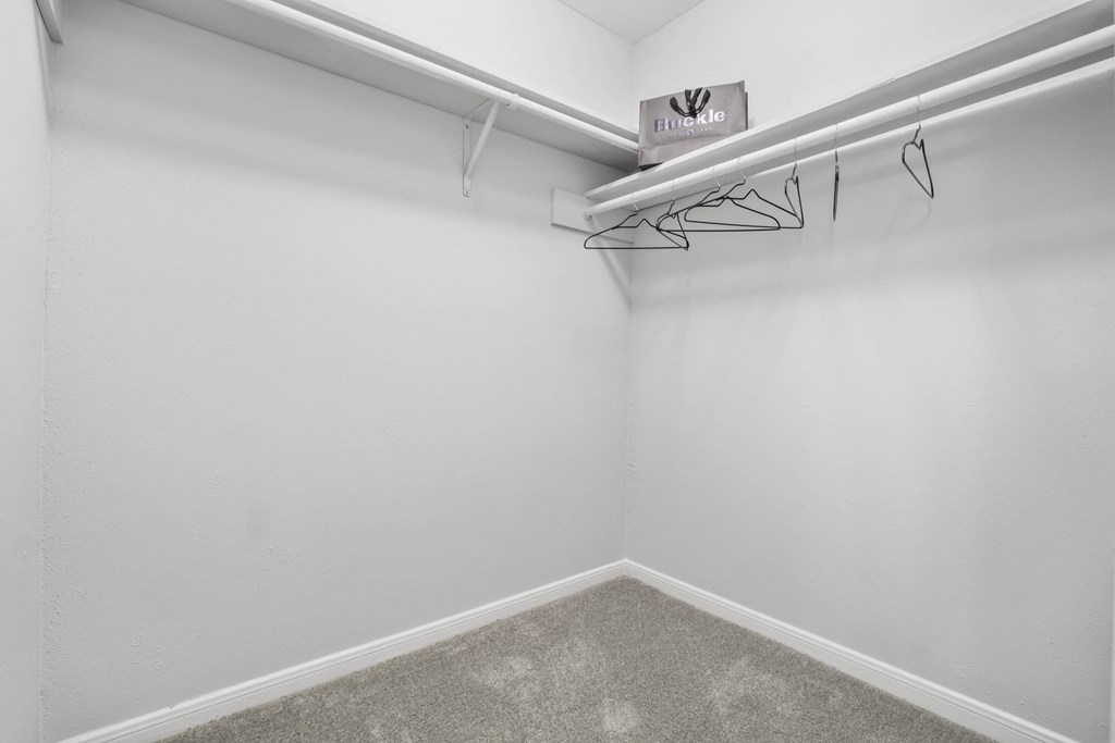 an empty room with white walls and a closet with a hanger on the wall