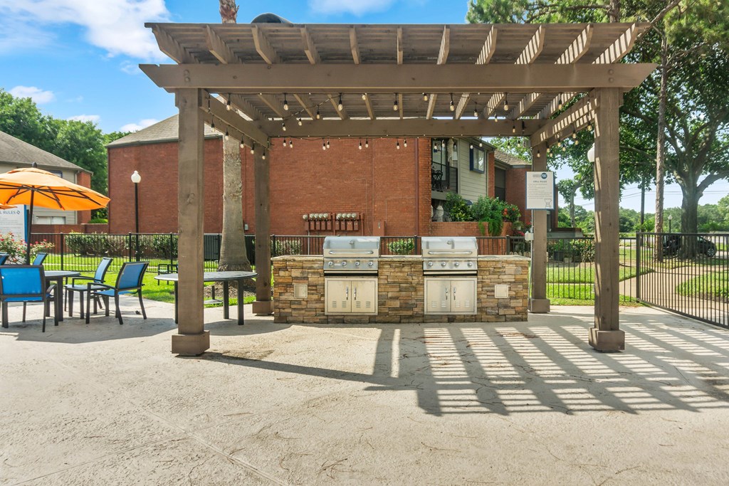 a patio with a barbecue grill and a pergola