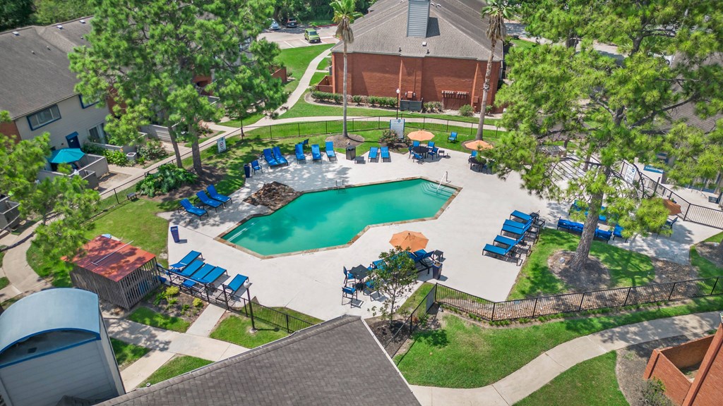 an aerial view of a swimming pool with chairs around it