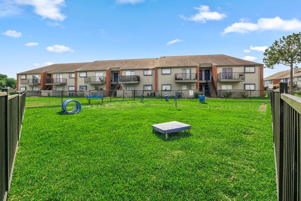 a yard with a playground and an apartment building