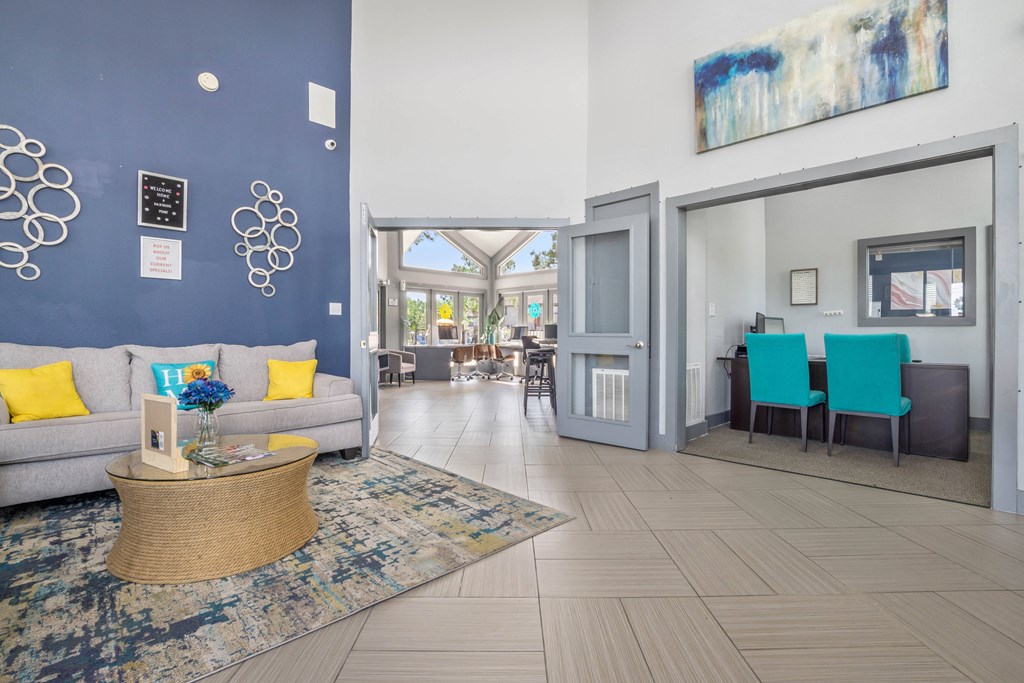 a living room and dining room with blue chairs and a couch and a rug