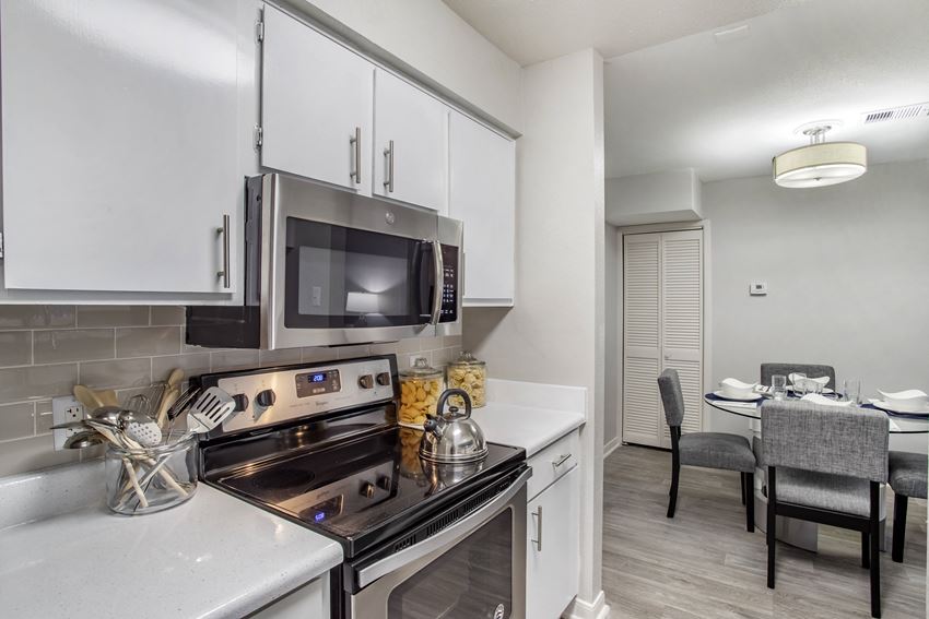 a kitchen with white cabinets and a stove and a microwave