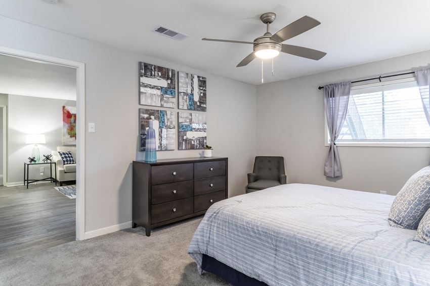 a bedroom with a bed and a ceiling fan