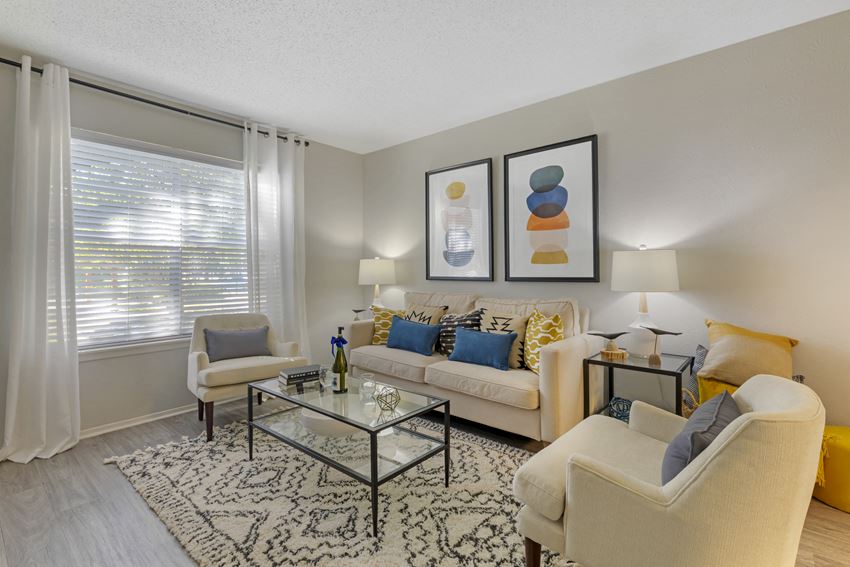 a living room with couches and chairs and a glass table