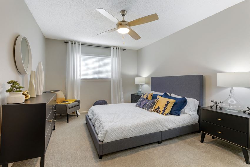 a bedroom with a large bed and a ceiling fan