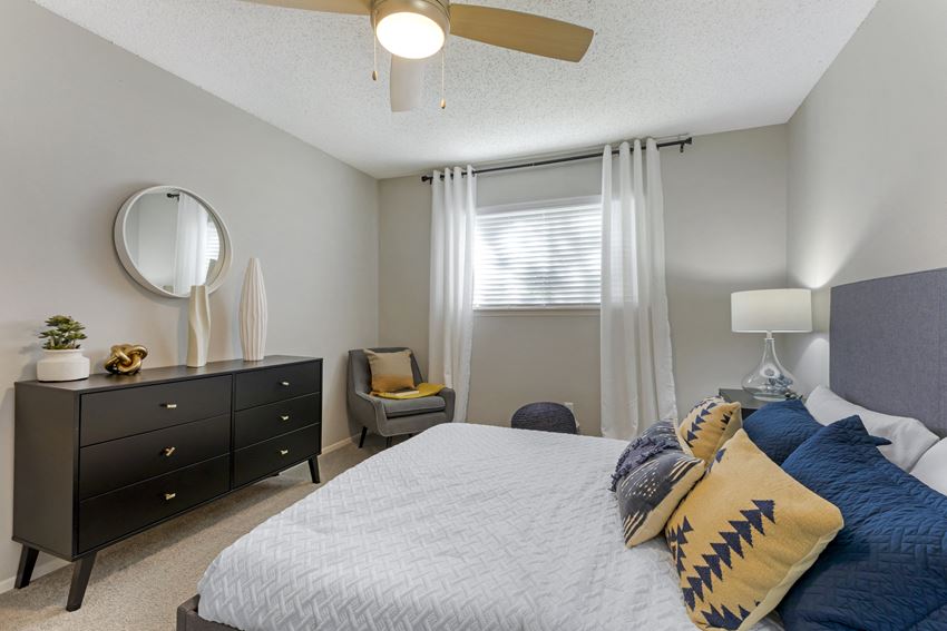 a bedroom with a bed and a dresser and a window