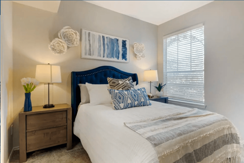 A bedroom with a white bed and a blue headboard.
