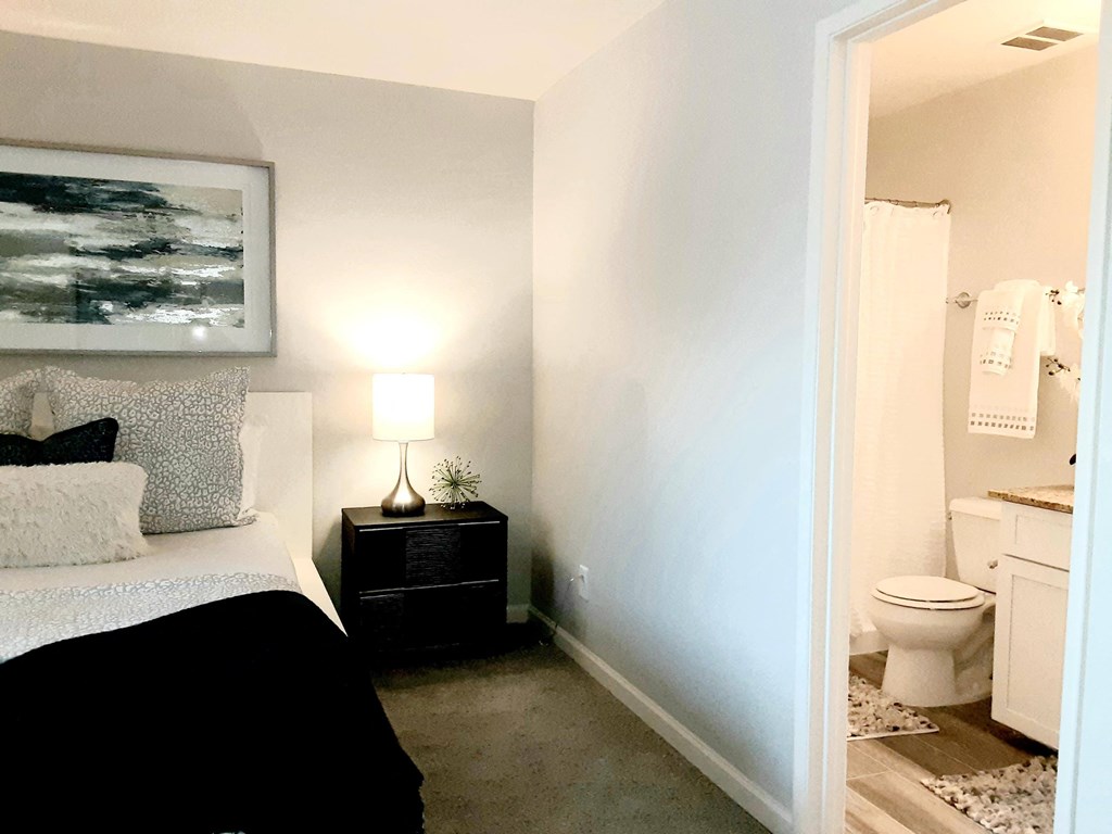 a bedroom with a bed and a bathroom with a toilet