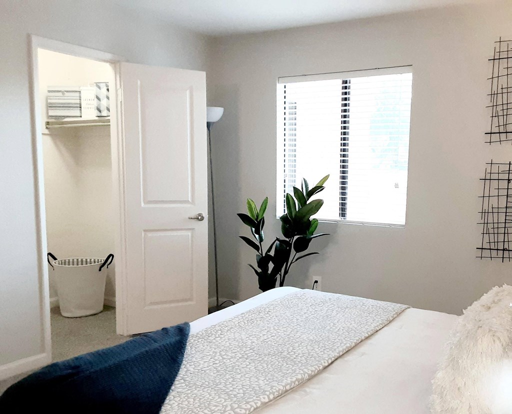 a bedroom with a bed and a white door and a window