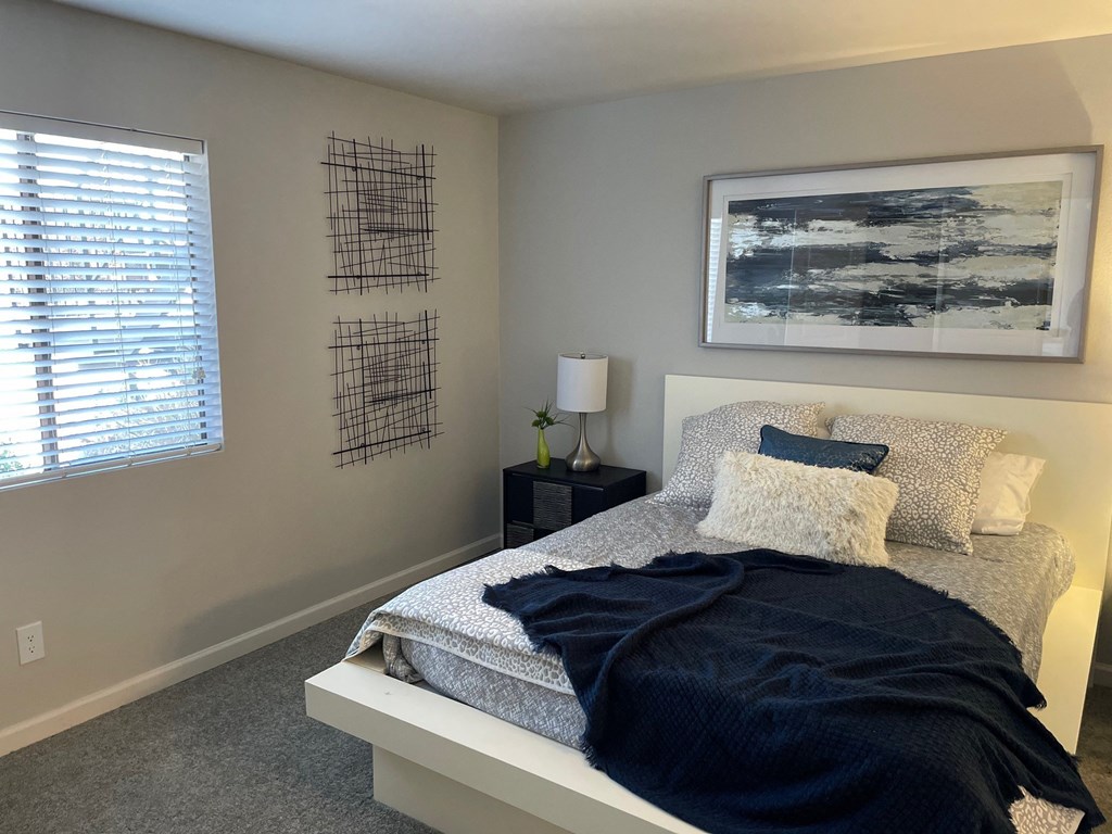 a bedroom with a bed and a painting on the wall