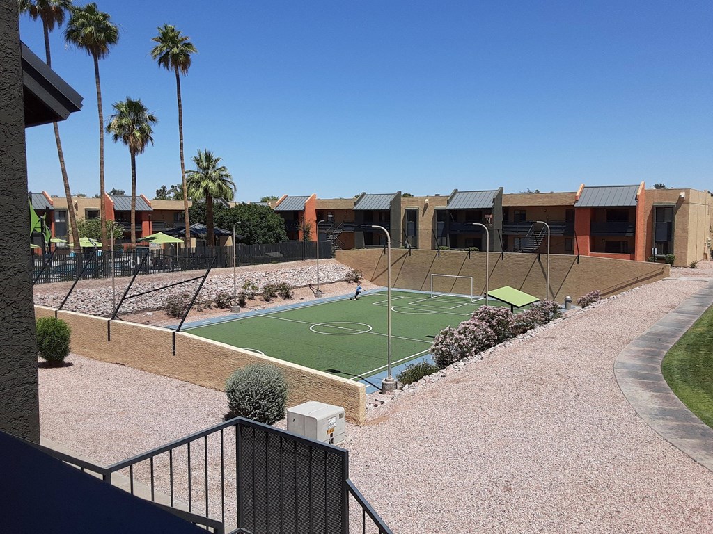 a tennis court in the middle of a house with palm trees