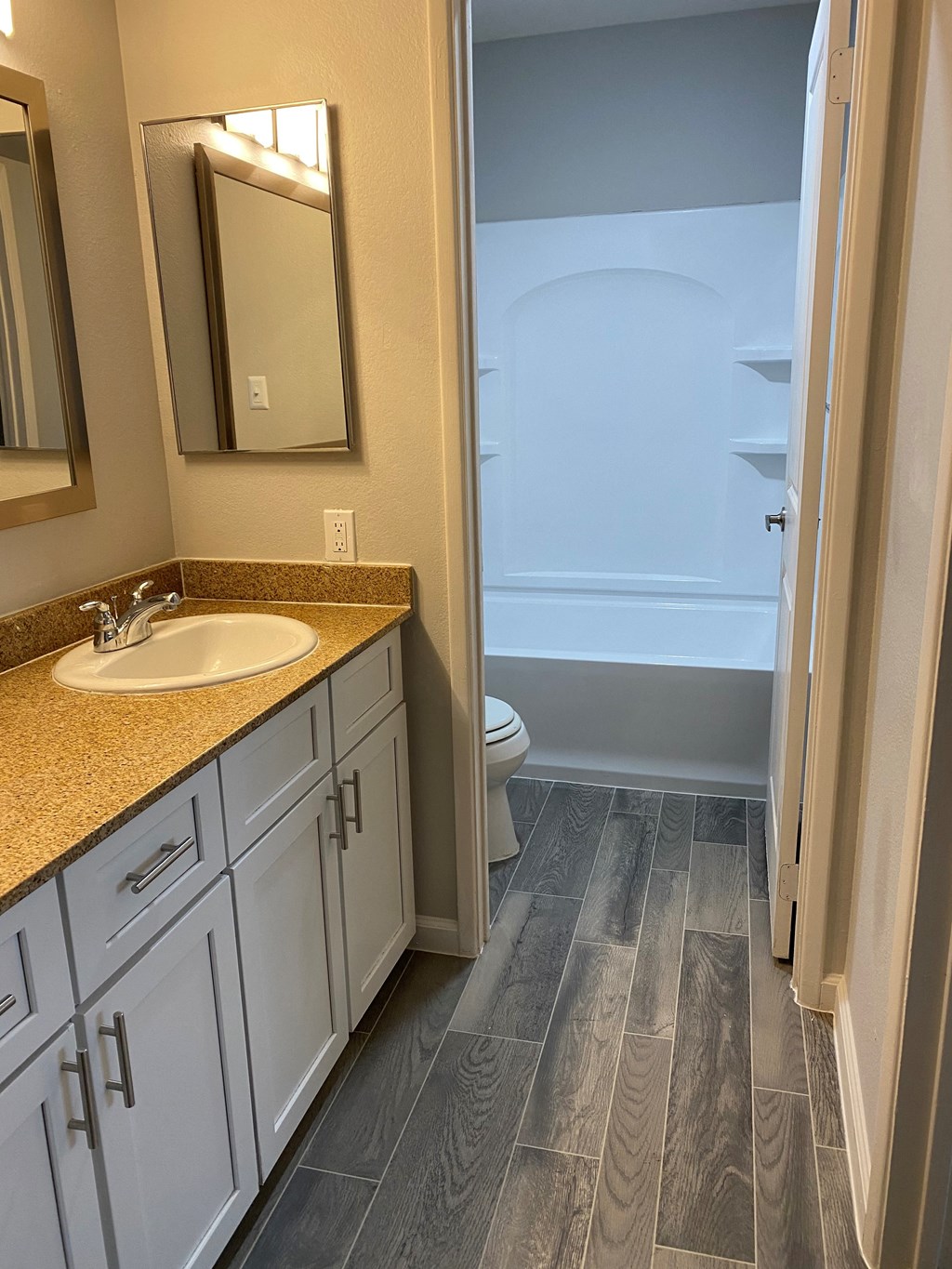a bathroom with white cabinets and a sink and a toilet