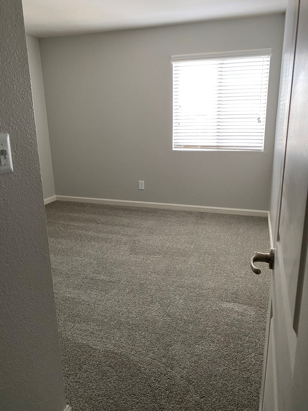 a room with a carpeted floor and a window