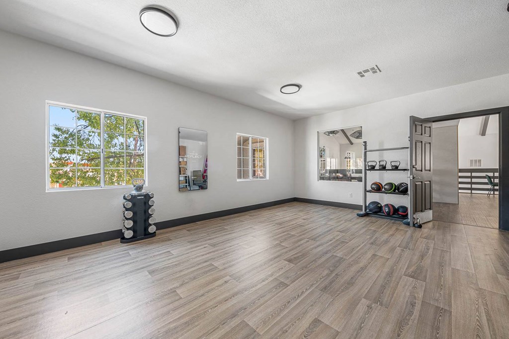 a workout room with a large window and hardwood floors