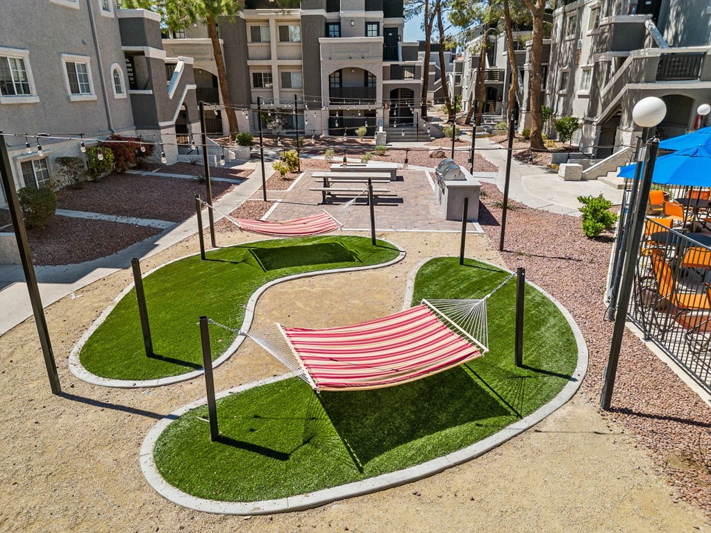 a park with a hammock in front of an apartment building