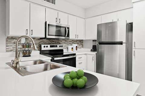 a kitchen with stainless steel appliances and white cabinets