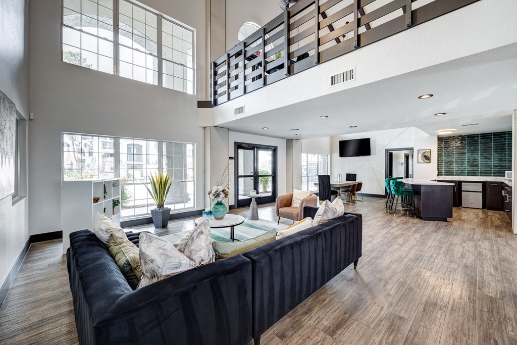 an open living room with a large black couch and a coffee table