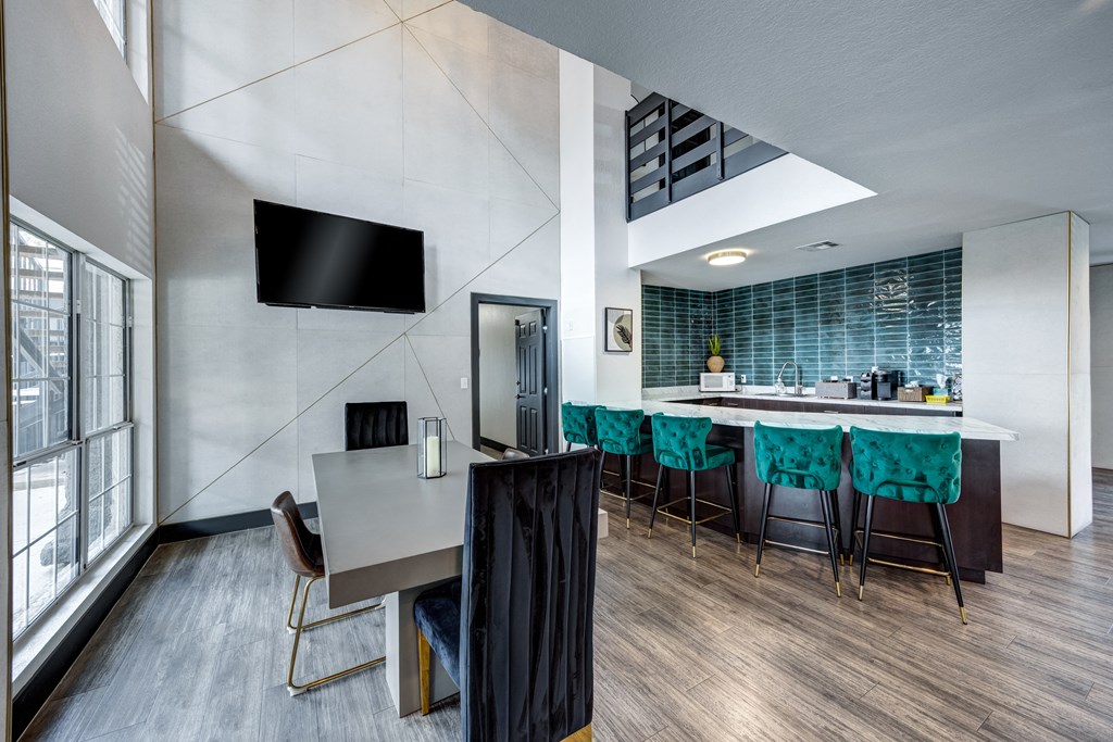 a kitchen and dining area in a hotel room with a table and chairs