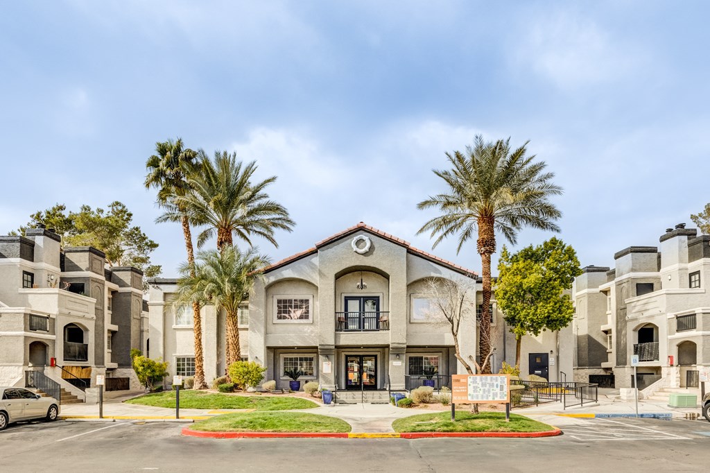 an apartment building with palm trees in front of it