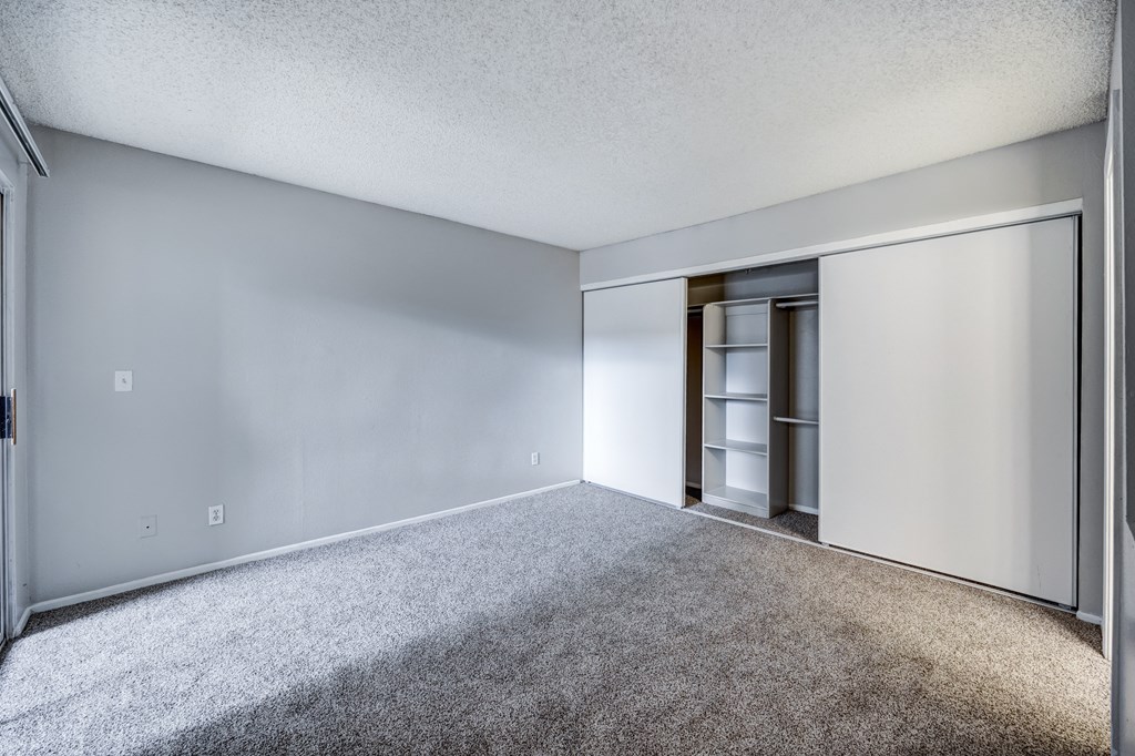 an empty living room with white walls and a closet