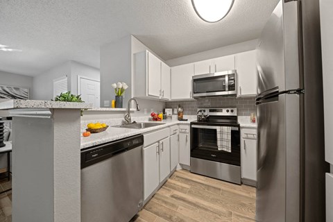 a kitchen with stainless steel appliances and white cabinets