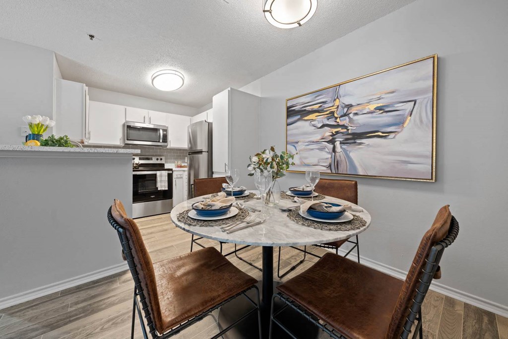 a dining room and kitchen with a table and chairs