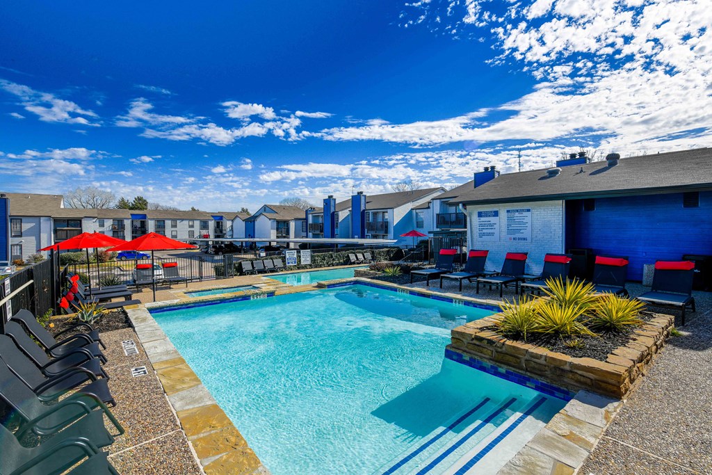 our apartments have a large swimming pool with chairs and umbrellas