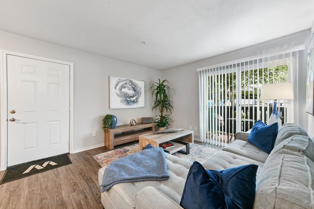 a living room with a couch and a door to a balcony