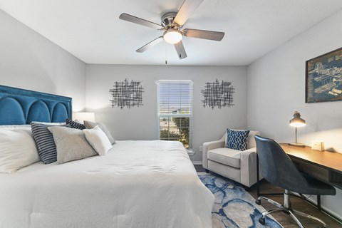 a bedroom with a large bed and a ceiling fan
