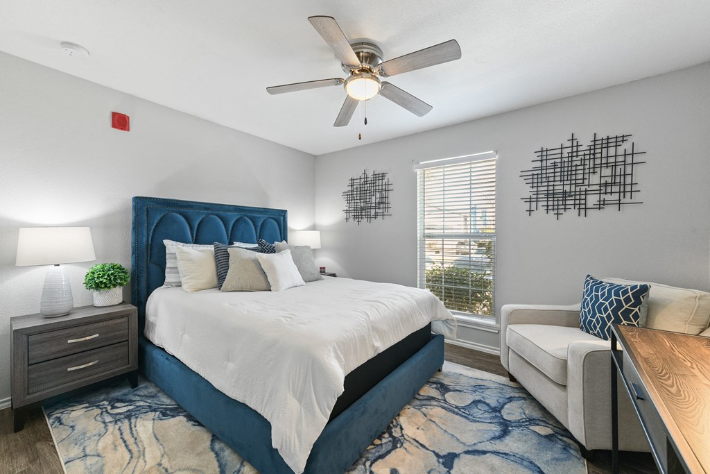 a bedroom with a large bed and a ceiling fan