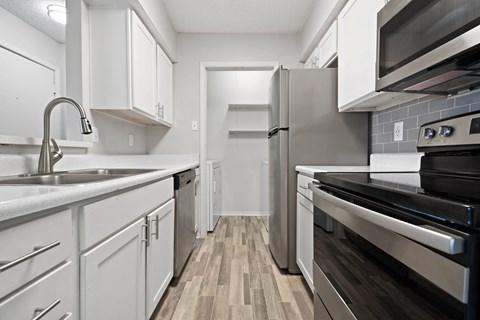 a kitchen with white cabinets and stainless steel appliances