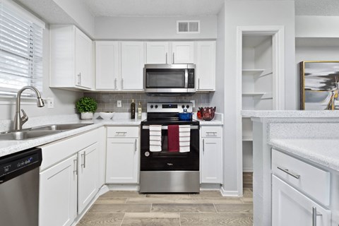 a kitchen with white cabinets and stainless steel appliances