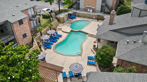 an aerial view of a pool and hot tub in the backyard of a home