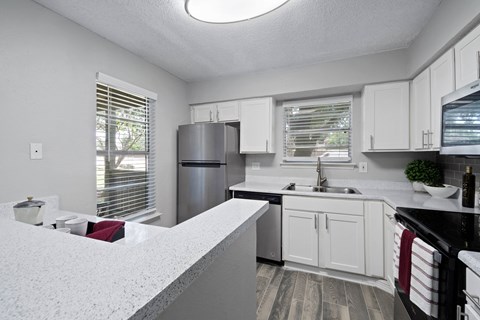 a kitchen with white cabinets and black appliances