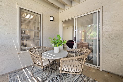 a patio with a table and chairs and a sliding glass door
