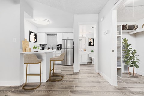an open kitchen and living room with a bar and stools