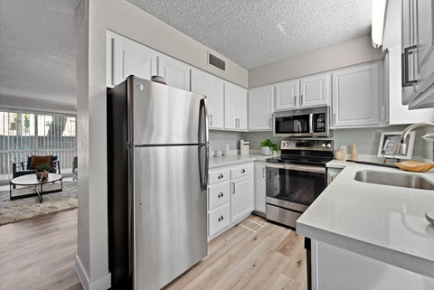 a kitchen with stainless steel appliances and white cabinets