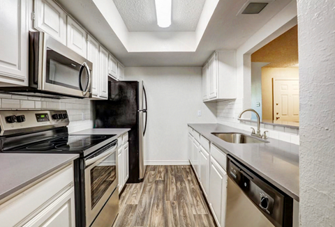 a renovated kitchen with white cabinets and stainless steel appliances