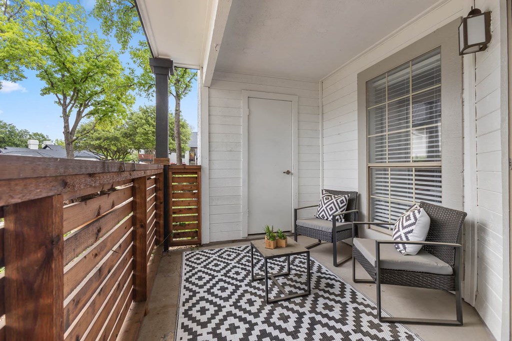 a porch with two chairs and a coffee table