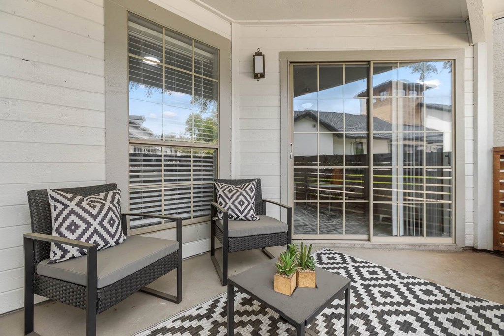 a patio with two chairs and a coffee table