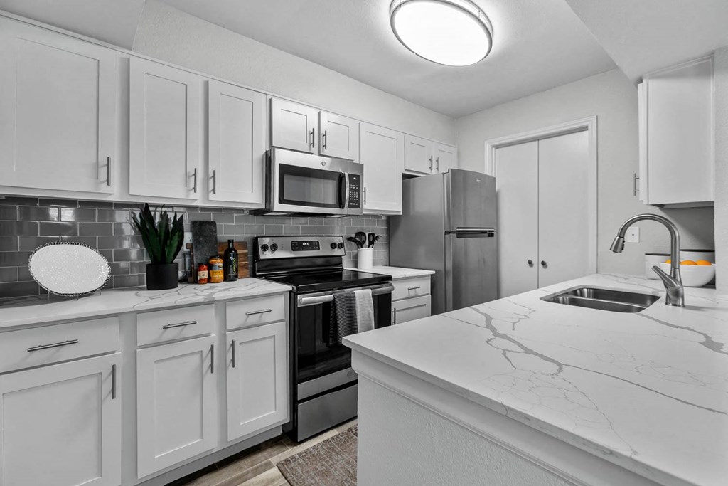 a kitchen with white cabinets and stainless steel appliances