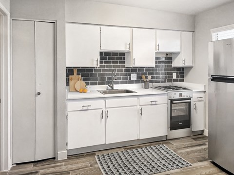 a kitchen with white cabinets and a stainless steel refrigerator