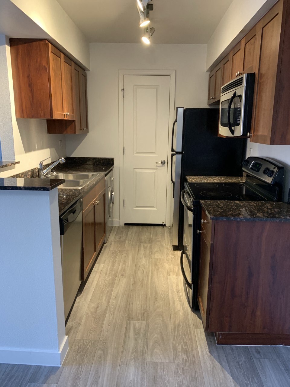 a kitchen with wooden cabinets and a black refrigerator