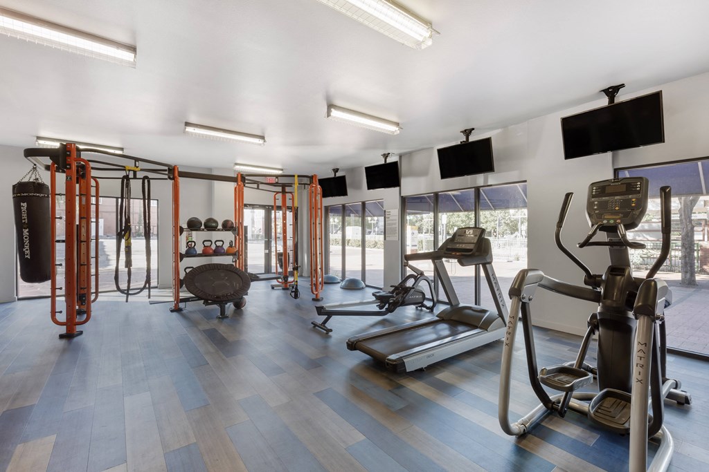 a gym with cardio equipment and windows in a building