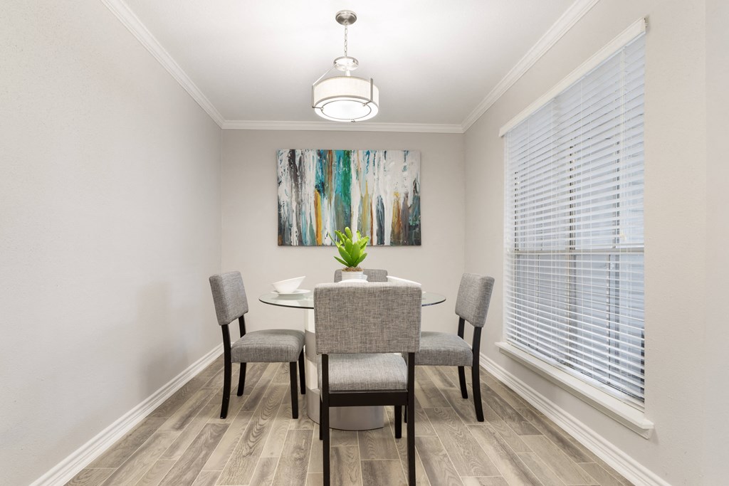 a dining room with a table and chairs and a window