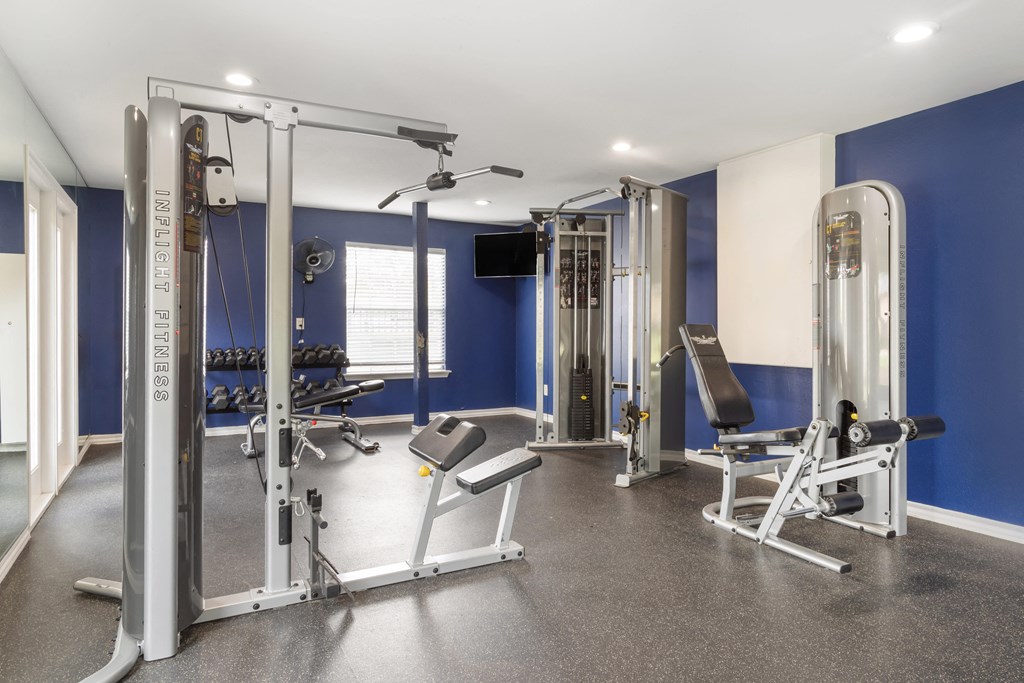 a gym with exercise equipment and weights in a home with blue walls